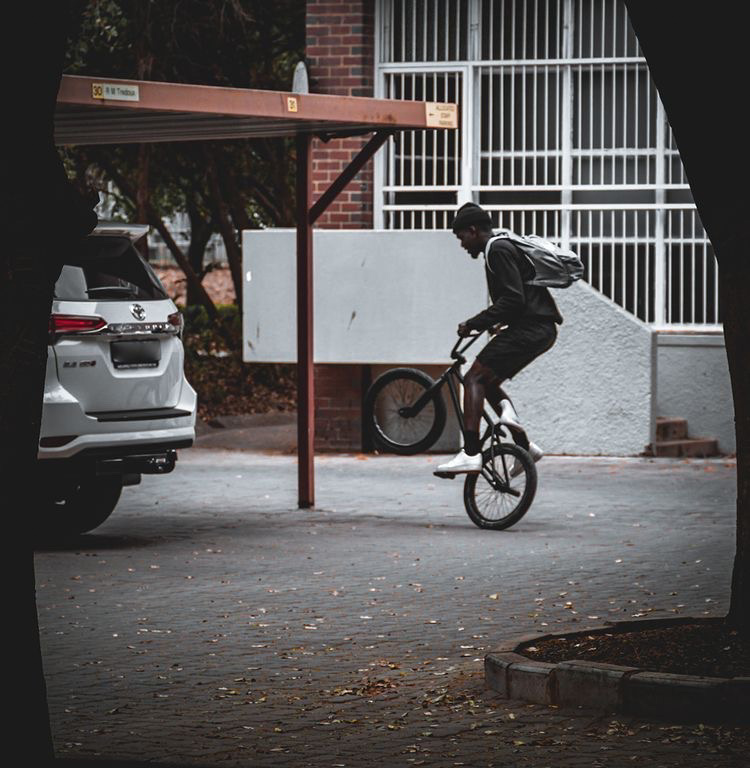 BMX rider near campus walkway and shadows