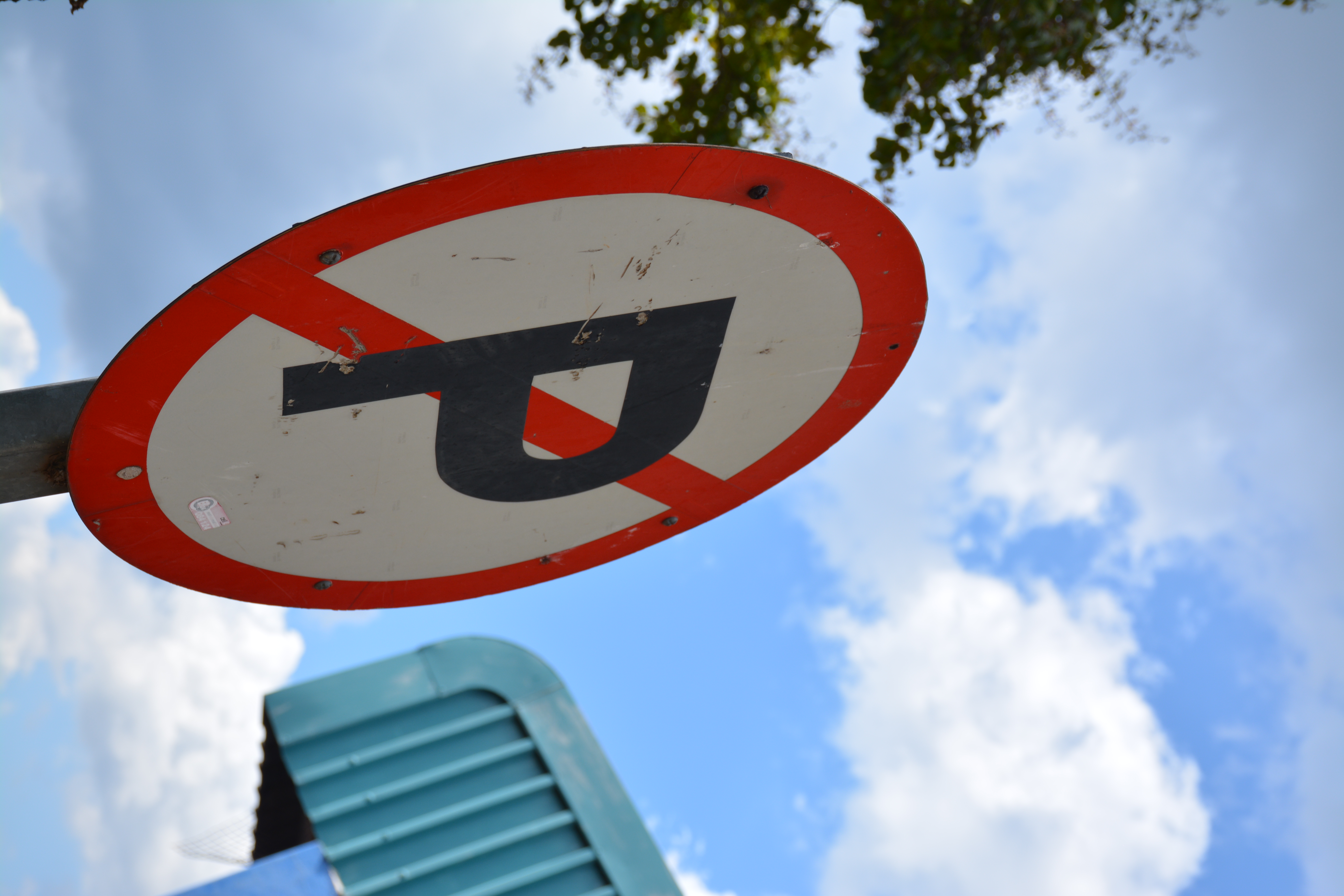 No parking sign photographed from a low angle against a blue sky