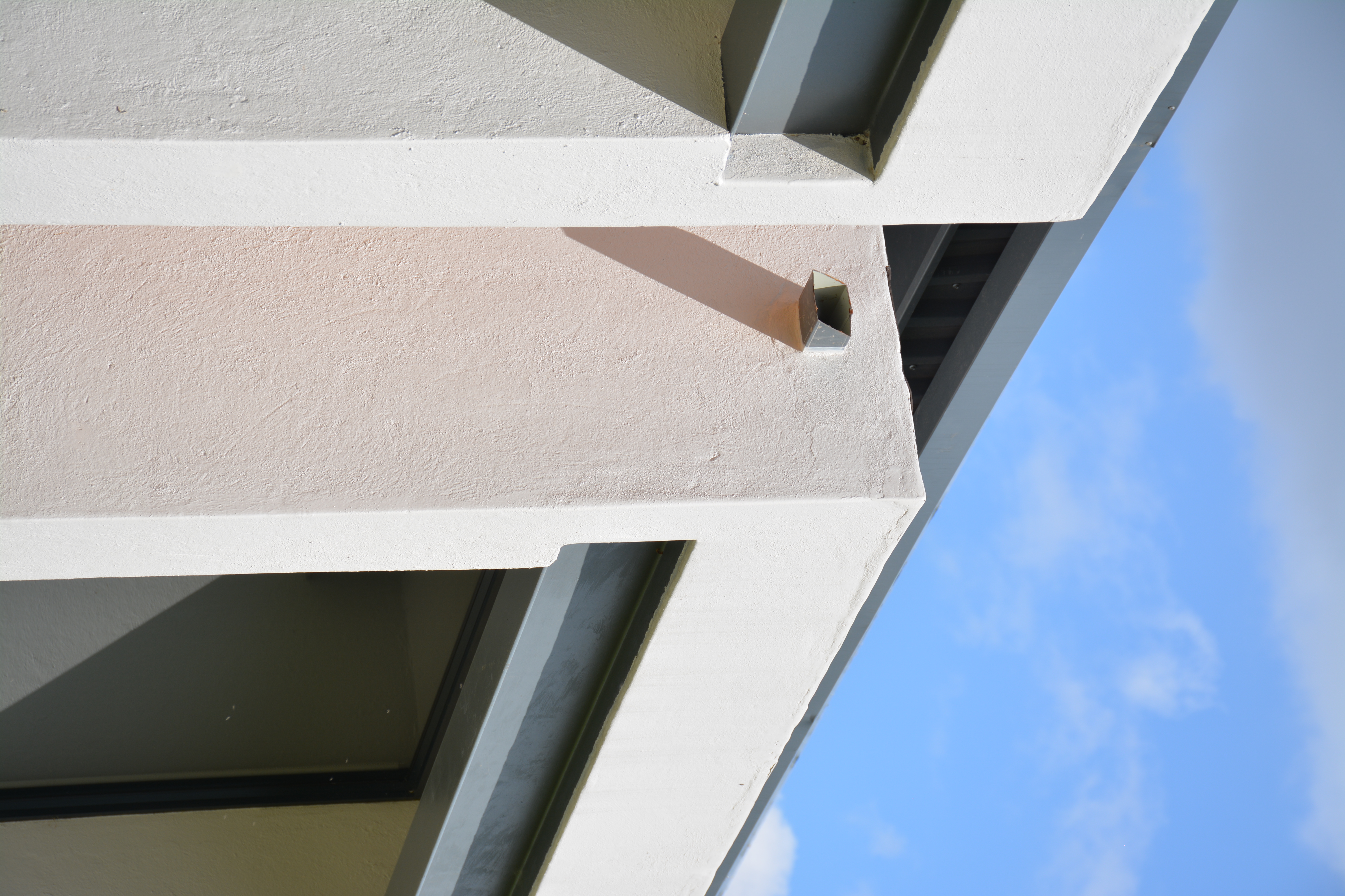 Pale wall and architectural corner against blue sky